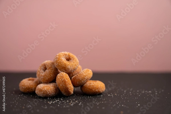 Obraz ピンク背景の山盛りになった小さなドーナツ