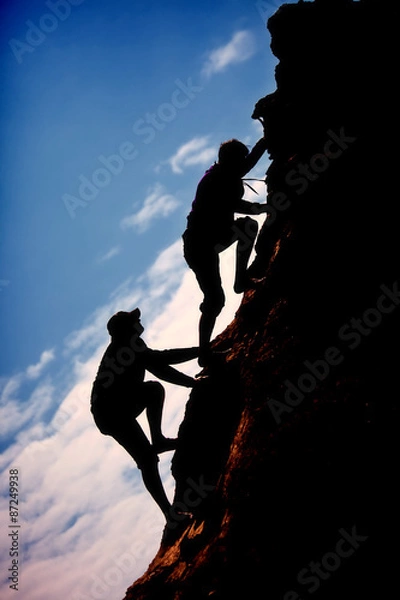 Fototapeta Siluet two men climb up the mountain