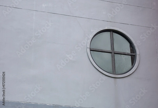 Obraz round glass window gray building wall