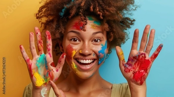 Obraz A woman with colorful paint on her face is smiling and holding her hands up. Generate AI