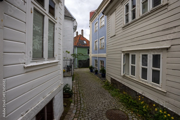 Fototapeta Charming old town alley with cobblestone path in Bergen, Norway