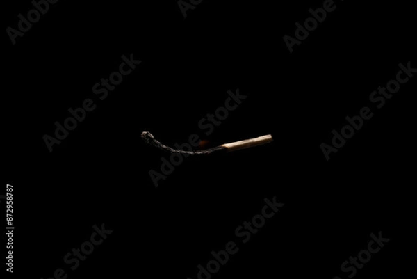 Obraz Lit falling match on a black background.
