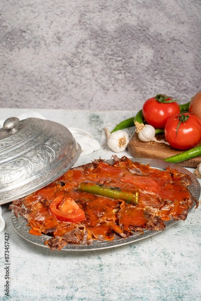 Fototapeta Iskender kebab. Traditional Turkish cuisine taste. Cooked iskender kebab with sauce and butter on a gray background. Close up