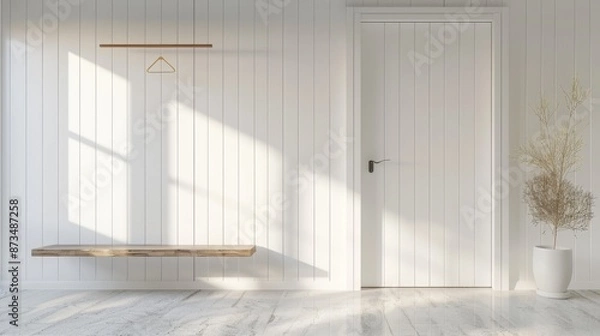 Fototapeta Design of a small bright room with white walls closed door and fluted wardrobe with wooden plank and hanger above cabinet