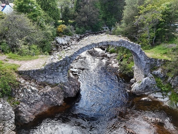 Obraz Carrbridge Packhorse Bridge, also known as Coffin Bridge, is a bridge in the village of Carrbridge in the Highlands of Scotland.