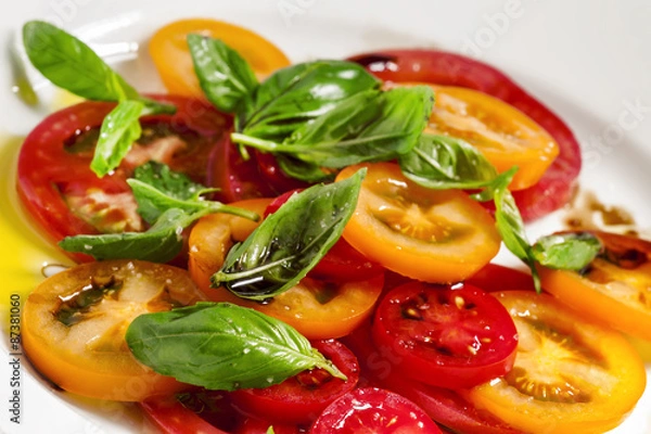 Fototapeta Vegetable salad of colorful tomatoes and basil with olive oil an
