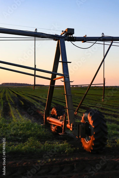 Fototapeta Field with mobile Irrigation system for water supply. Automatic field watering system.