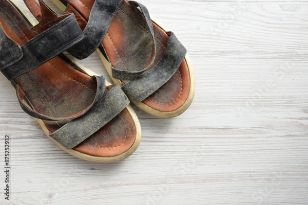Fototapeta Prevent and remove mould from leather shoes. Summer shoes with abundant mould on a light wood background, top view, with space for text. mould from leather shoes. ill-fitting shoes