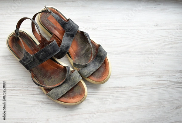 Fototapeta Prevent and remove mould from leather shoes. Summer shoes with abundant mould on a light wood background, top view, with space for text. mould from leather shoes. ill-fitting shoes