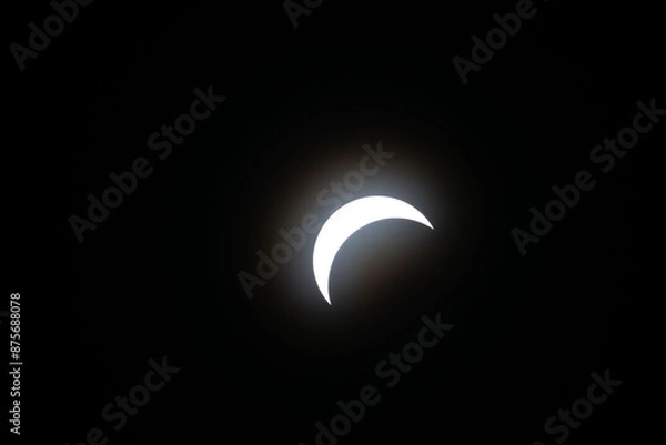Fototapeta Total eclipse waxing as moon begins to cover the sun
