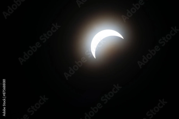 Fototapeta Total eclipse waxing as moon begins to cover the sun