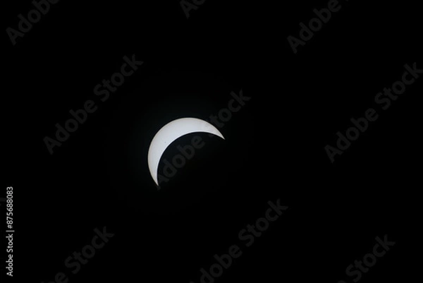 Fototapeta Total eclipse waxing as moon begins to cover the sun