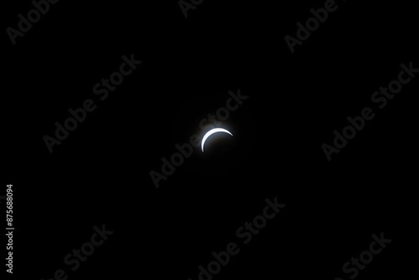 Fototapeta Total eclipse waxing as moon begins to cover the sun