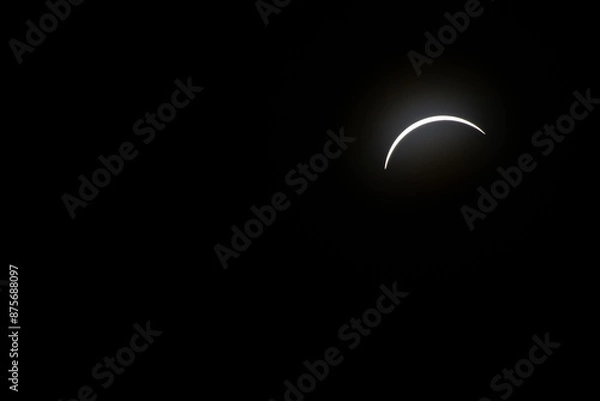 Fototapeta Total eclipse waxing as moon begins to cover the sun