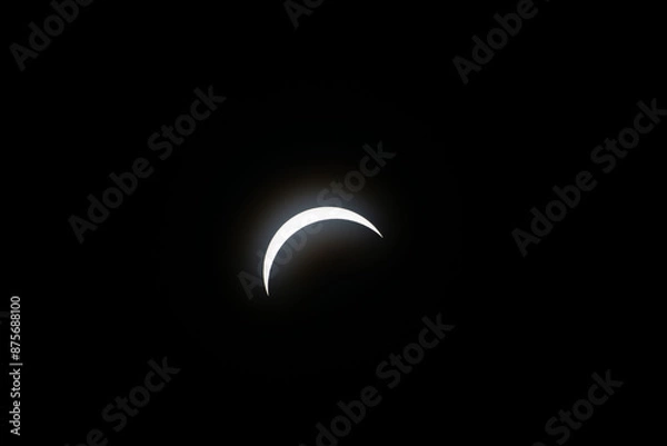 Fototapeta Total eclipse waxing as moon begins to cover the sun