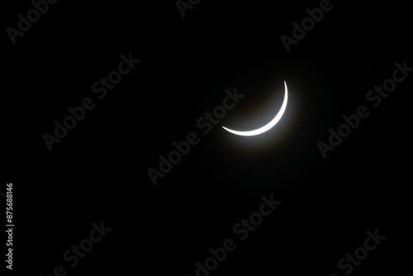 Fototapeta Total eclipse waning as moon begins to uncover the sun