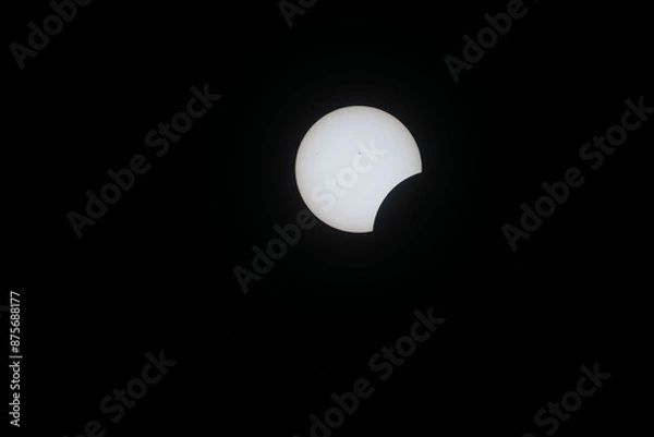 Fototapeta Total eclipse waxing as moon begins to cover the sun
