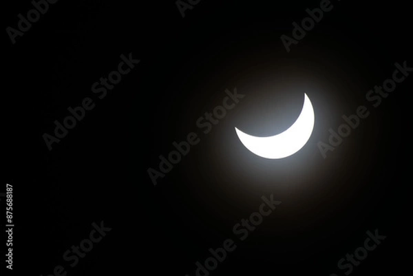 Fototapeta Total eclipse waning as moon begins to uncover the sun