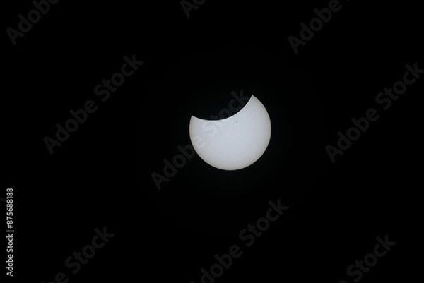 Fototapeta Total eclipse waning as moon begins to uncover the sun