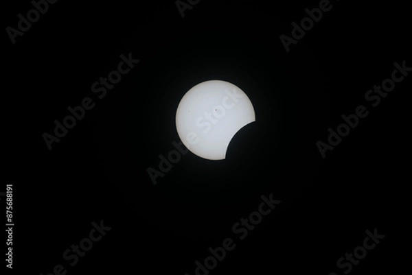 Fototapeta Total eclipse waxing as moon begins to cover the sun