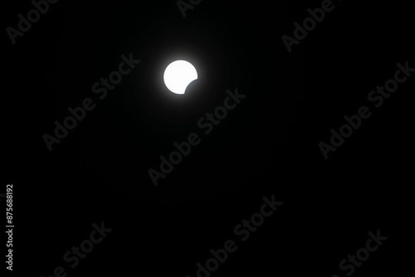 Fototapeta Total eclipse waxing as moon begins to cover the sun