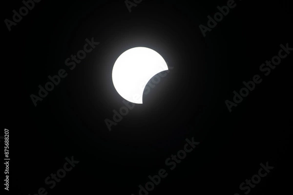 Fototapeta Total eclipse waxing as moon begins to cover the sun
