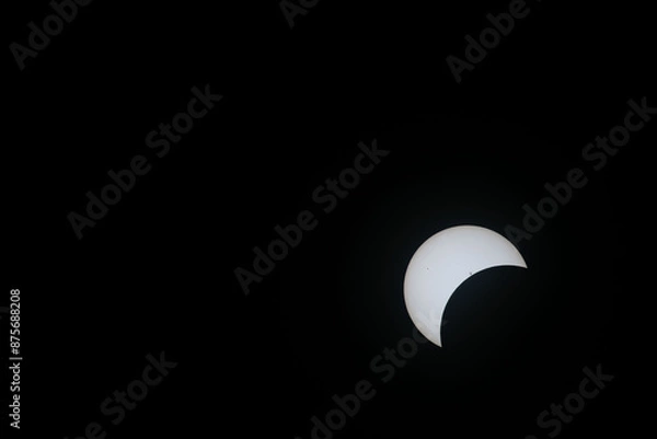 Fototapeta Total eclipse waxing as moon begins to cover the sun