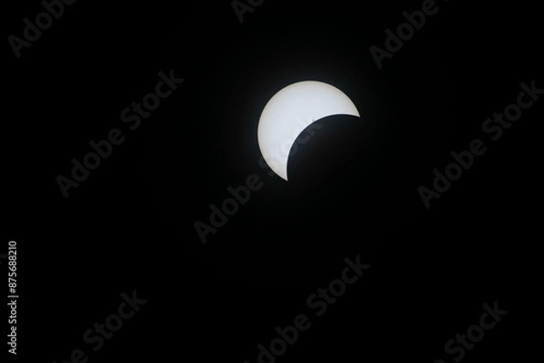 Fototapeta Total eclipse waxing as moon begins to cover the sun