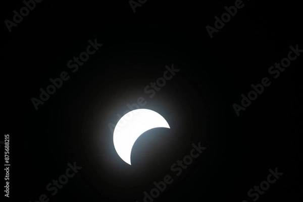 Fototapeta Total eclipse waxing as moon begins to cover the sun