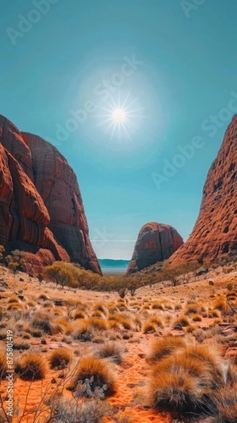 Fototapeta A desert landscape with a sun shining brightly in the sky