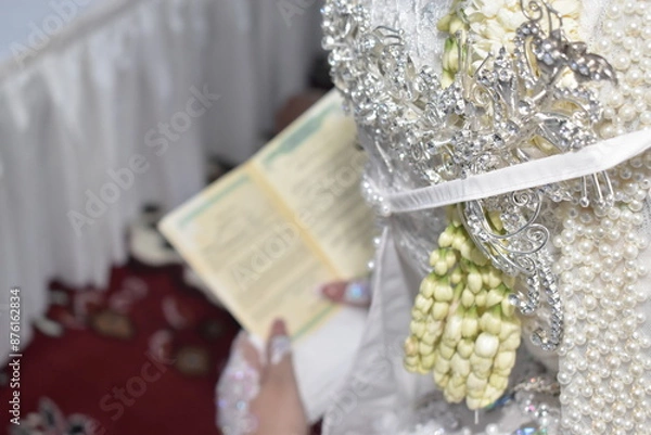 Fototapeta The bride is reading the wedding book photographed from behind