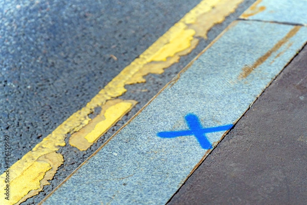 Fototapeta replacing a curb marked with a blue cross
