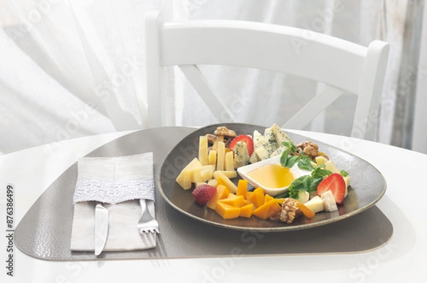 Obraz Cheese platter with different cheese and fruits on a white background. Appetizer for party.