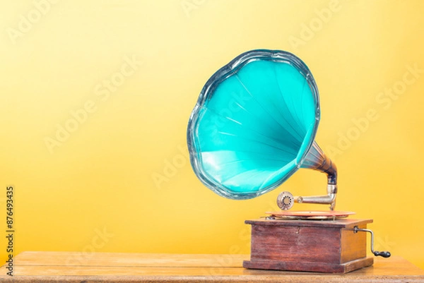 Obraz Vintage antique gramophone phonograph turntable with mint blue horn on oak table front yellow background. Retro style filtered photo
