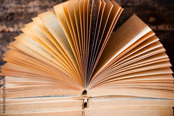 Fototapeta old open book lying on the other with a fan and pages
