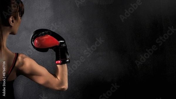 Fototapeta  Woman Boxer Biceps with Red Boxing Glove on Black Background, high contrast with saturated grunge filter