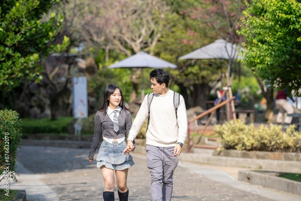 Fototapeta In March, a Taiwanese woman in her twenties and a Hong Kong man are walking in a park near Zhongshan Memorial Hall in Zhongzheng District, Taipei City, Taiwan.