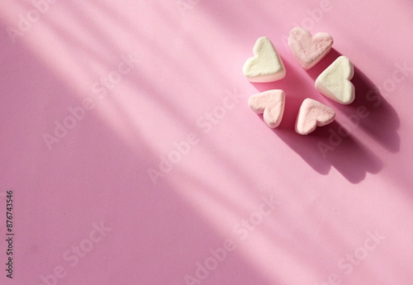Fototapeta Marshmallow hearts on a pink background with copy space. Romantic pink background. Valentine's Day symbols tender marshmallow sweets heart shape.