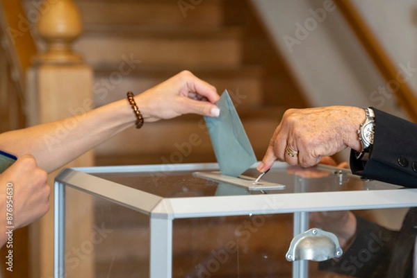 Fototapeta vote en république française, enveloppe glissée dans une urne transparente et ouverte  avec un clapet par un assesseur