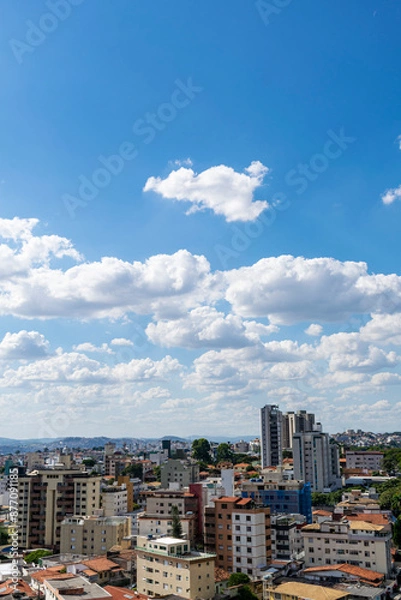 Fototapeta Beautiful blue sky with clouds. Residential buildings. Space for advertising. Vertical.
