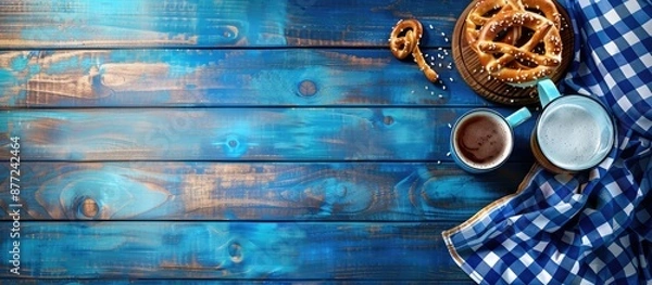 Fototapeta Bavarian flag beer mug and pretzels on blue wood ideal for copy space image