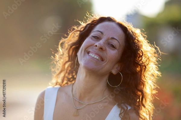 Obraz Beautiful middle age woman smiling. Back light at sunset.