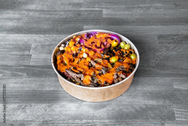 Obraz A flavorful beef salad bowl topped with olives and drizzled with spicy sauce. Perfect for healthy eating and vibrant culinary presentations.
