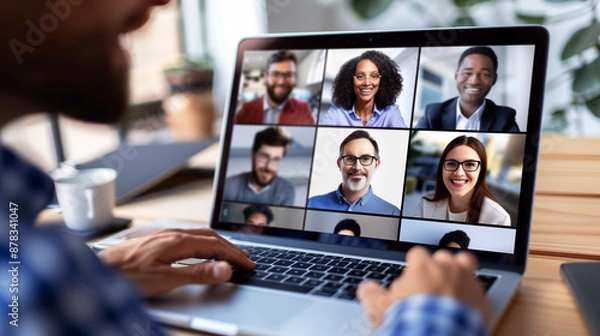 Obraz Online meeting with colleagues' faces in a grid on a laptop, captured in a clean, light workspace.

