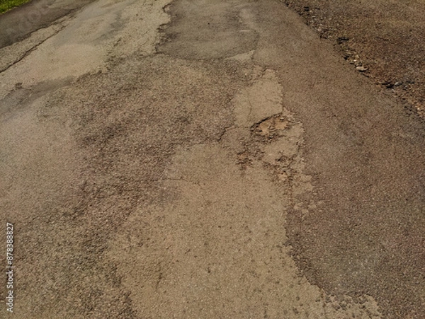 Fototapeta A close-up shot of a cracked and weathered asphalt road surface