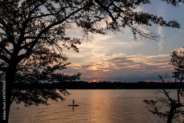 Fototapeta Beautiful sky and lake with boats, people relaxing on the shore at sunset. Beautiful orange and blue sky at dawn. Lake Bowen Anchor Park, Inman, SC, USA 