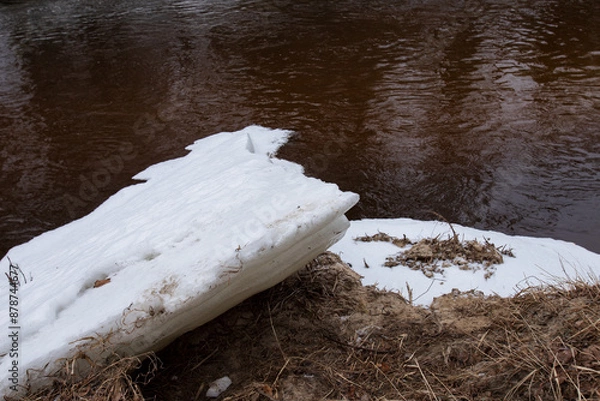 Obraz two large white ice floes on the riverbank after winter, one lying on top of the other