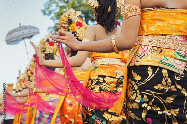 Obraz Grupa pięknych Balijczyków w jasnych tradycyjnych strojach - sarongach ozdobionych hinduskimi maskami Barong i Garuda. Sztuka i kultura ludzi z wyspy Bali i Indonezji oraz azjatyckich środowisk podróżniczych