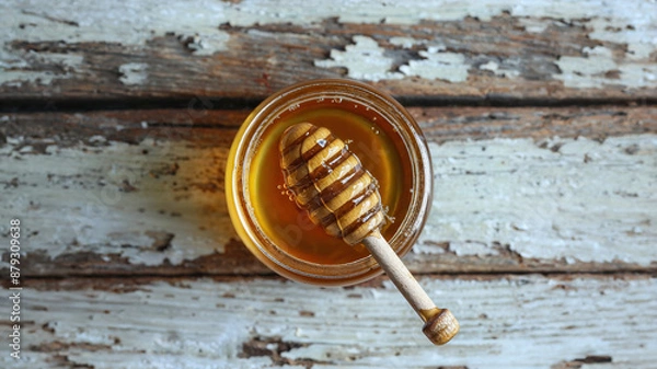 Fototapeta Jar of Honey with Wooden Dipper on Rustic Table
