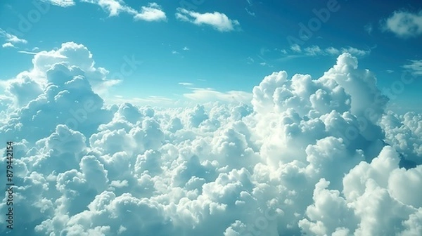 Fototapeta A view from inside an airplane looking out at fluffy white clouds against a blue sky